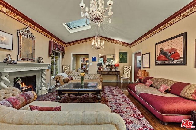 living room featuring hardwood / wood-style flooring, a fireplace, lofted ceiling with skylight, and a chandelier