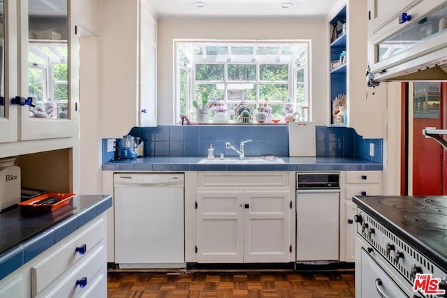 kitchen with sink, white cabinetry, tile counters, dishwasher, and decorative backsplash