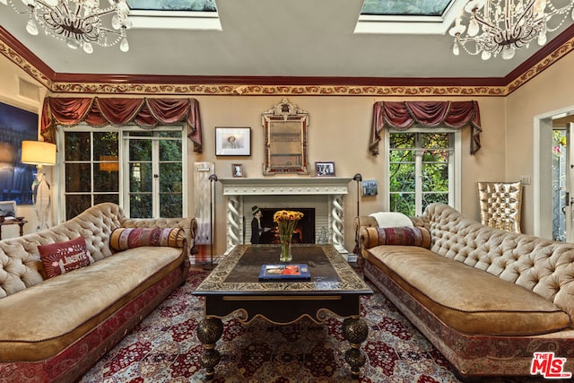 living room with a notable chandelier, a fireplace, and a skylight