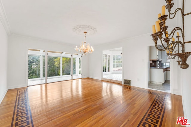 interior space with a notable chandelier, crown molding, and plenty of natural light