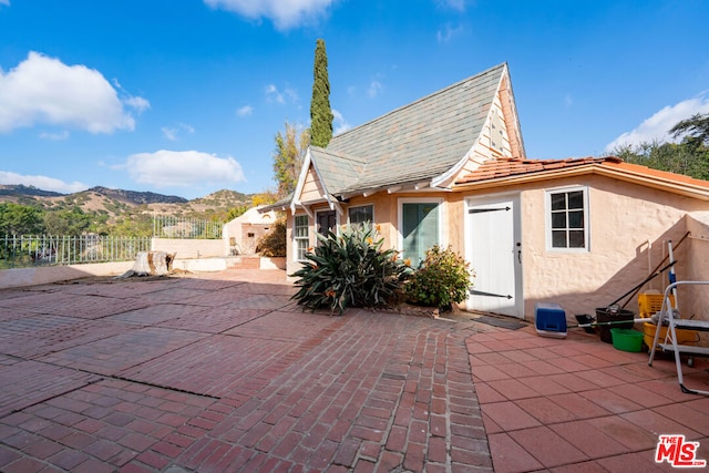 rear view of house with a mountain view and a patio area