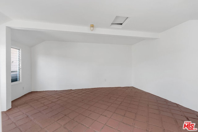 spare room with lofted ceiling with beams