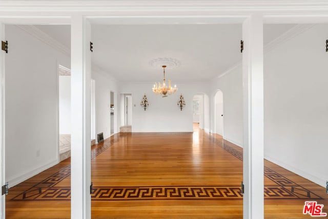 interior space featuring crown molding, an inviting chandelier, a barn door, and hardwood / wood-style floors