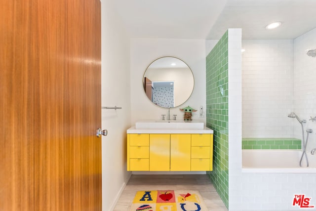 bathroom featuring vanity and a relaxing tiled tub