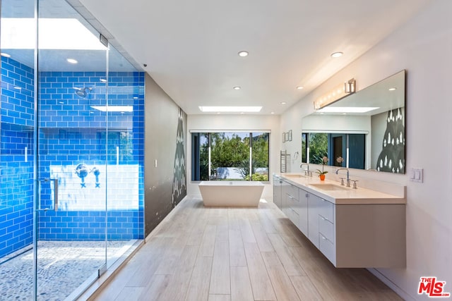 bathroom with hardwood / wood-style flooring, vanity, and shower with separate bathtub