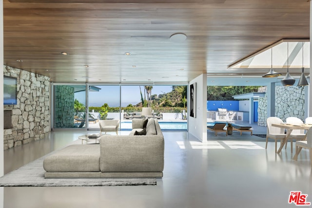 living room featuring concrete flooring and wood ceiling