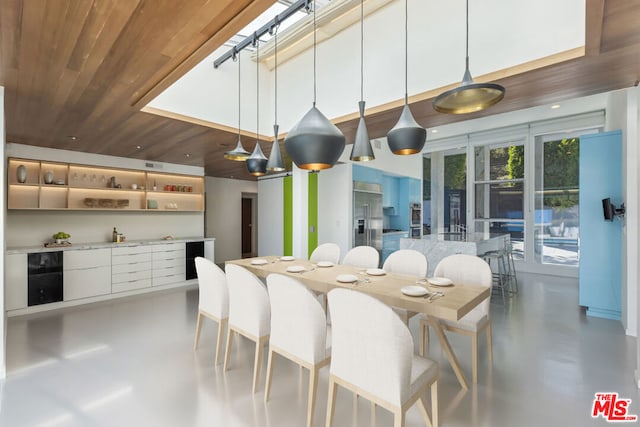 dining room featuring wine cooler, wooden ceiling, and concrete floors