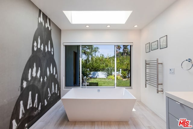 bathroom with vanity, radiator heating unit, a bathtub, and wood-type flooring