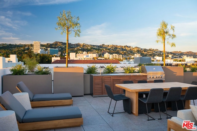 view of patio with an outdoor kitchen and a grill