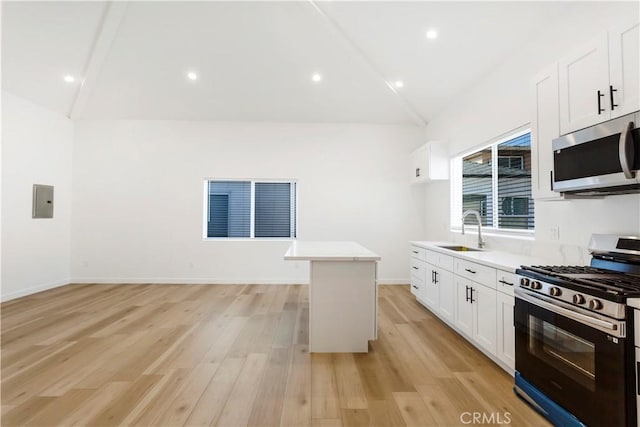 kitchen featuring sink, appliances with stainless steel finishes, a kitchen island, light hardwood / wood-style floors, and white cabinets