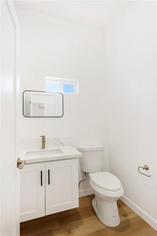 bathroom with vanity, wood-type flooring, and toilet