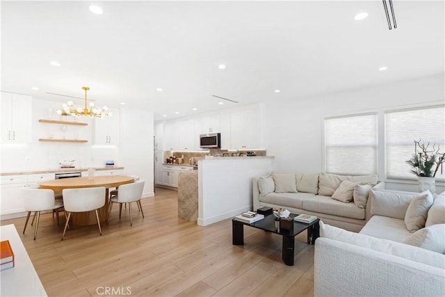 living room featuring a notable chandelier and light hardwood / wood-style flooring