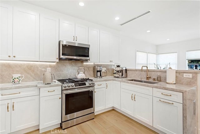 kitchen featuring stainless steel appliances, sink, and white cabinets