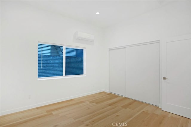 spare room with hardwood / wood-style flooring and a wall unit AC