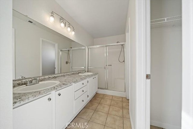 bathroom featuring tile patterned flooring, vanity, and an enclosed shower