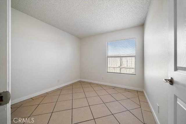 tiled spare room featuring a textured ceiling