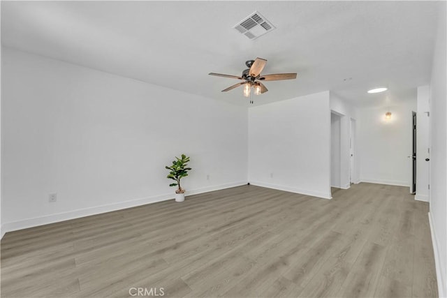 spare room featuring visible vents, baseboards, light wood-style floors, and a ceiling fan