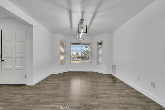 unfurnished dining area featuring wood finished floors, visible vents, and baseboards