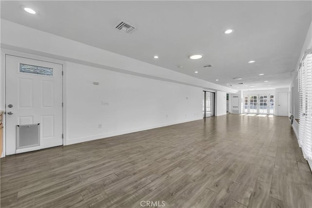 unfurnished living room with visible vents, recessed lighting, baseboards, and wood finished floors