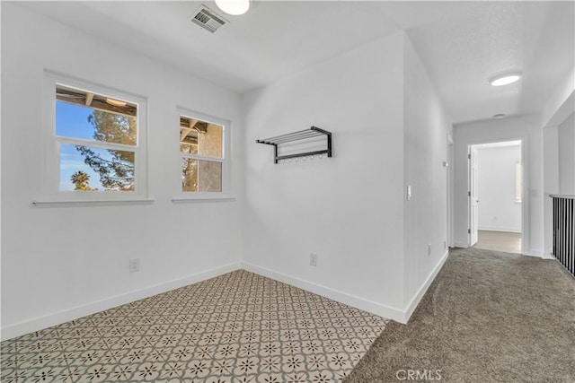 empty room featuring baseboards and visible vents