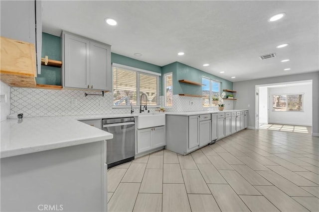 kitchen featuring visible vents, open shelves, a sink, tasteful backsplash, and stainless steel dishwasher