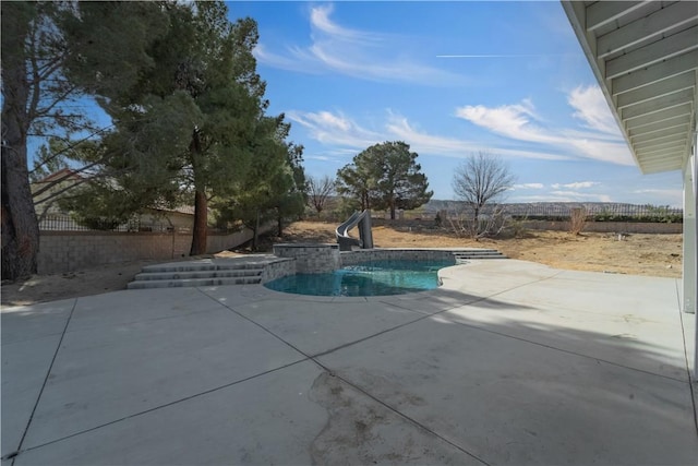 outdoor pool featuring a fenced backyard, a water slide, and a patio