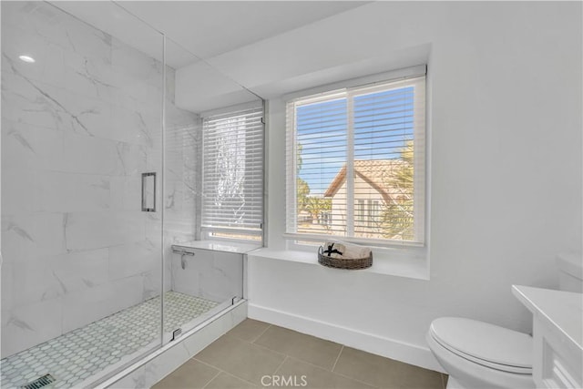 full bathroom with a marble finish shower, toilet, and baseboards