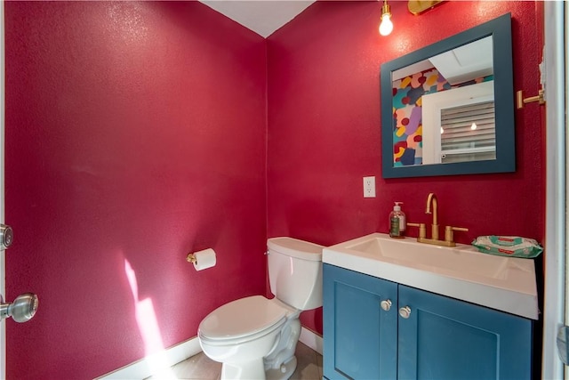 bathroom with vanity, toilet, and baseboards