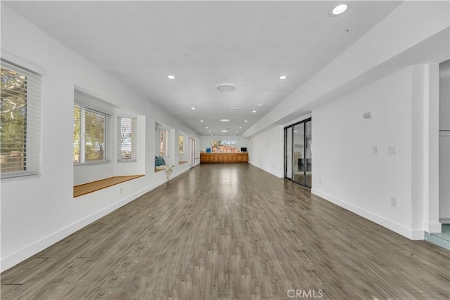 unfurnished living room featuring recessed lighting, baseboards, and wood finished floors