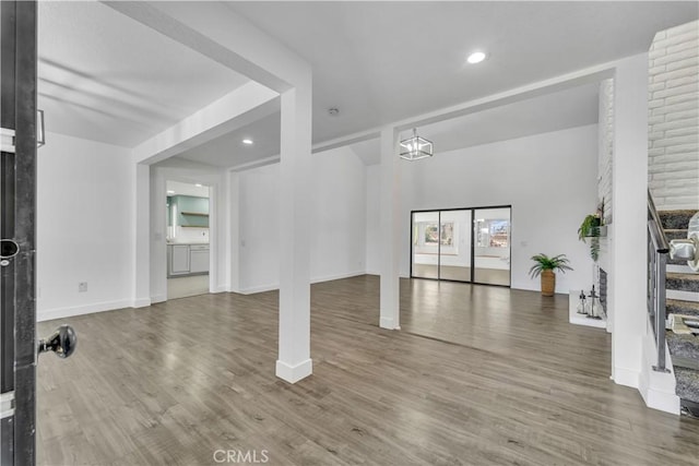 living area featuring recessed lighting, baseboards, wood finished floors, and stairs