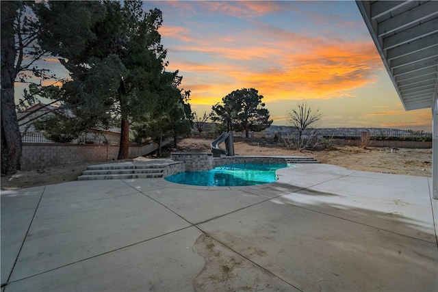 view of pool with a patio area, a fenced in pool, a water slide, and fence