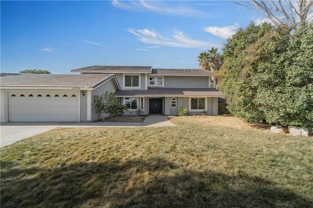 traditional-style home featuring a garage, a front yard, and driveway