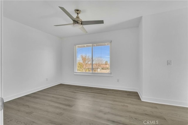 empty room with wood finished floors, baseboards, and ceiling fan