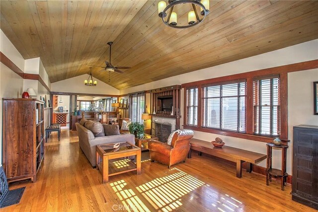 living room featuring lofted ceiling, a ceiling fan, wood finished floors, wood ceiling, and a fireplace