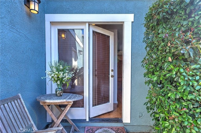 view of exterior entry featuring stucco siding