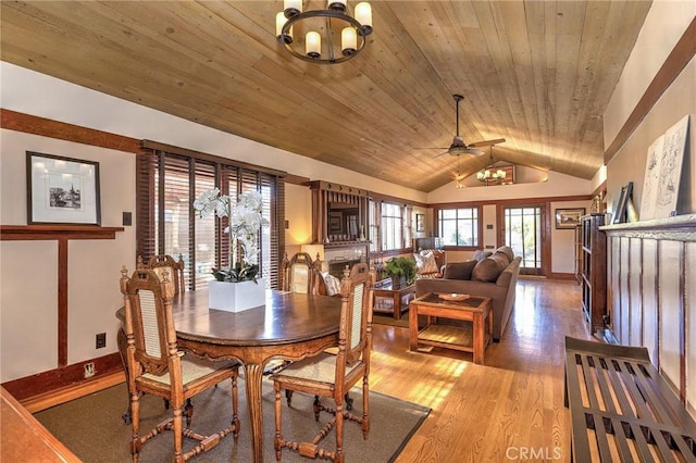 dining room featuring wood ceiling, vaulted ceiling, ceiling fan with notable chandelier, and light wood-type flooring