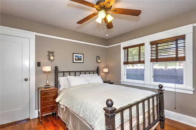 bedroom featuring a ceiling fan, baseboards, and dark wood-style flooring