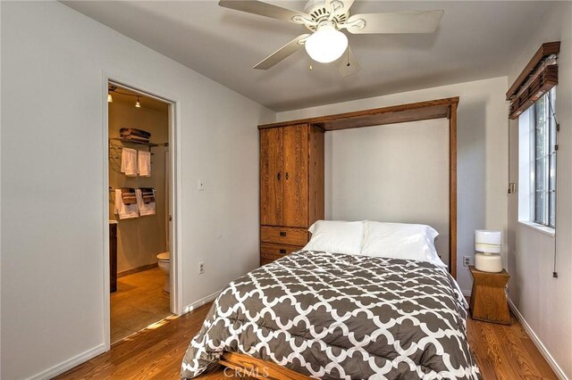 bedroom featuring hardwood / wood-style floors, ensuite bath, and ceiling fan