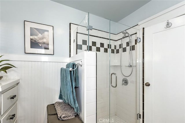 full bath with a wainscoted wall, vanity, and a stall shower
