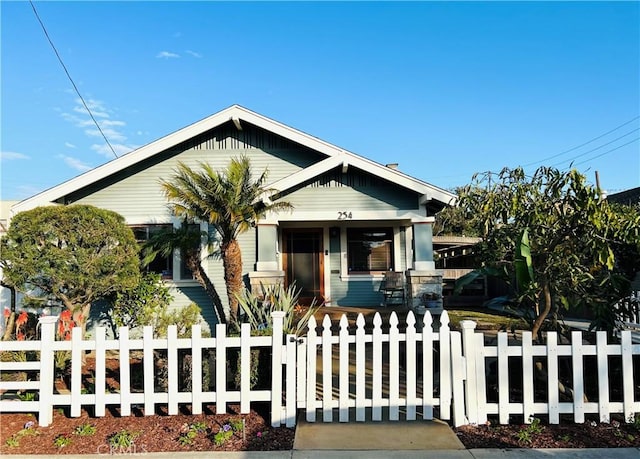 bungalow-style house with a porch and a fenced front yard