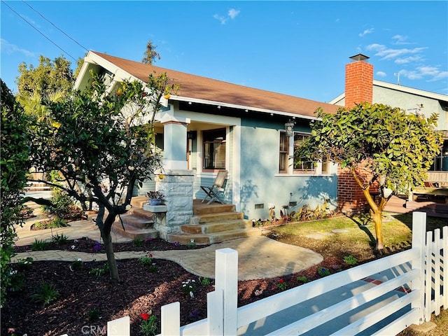 view of front of property featuring a chimney, covered porch, fence, crawl space, and stucco siding
