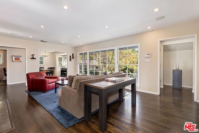 living room with an inviting chandelier and dark wood-type flooring