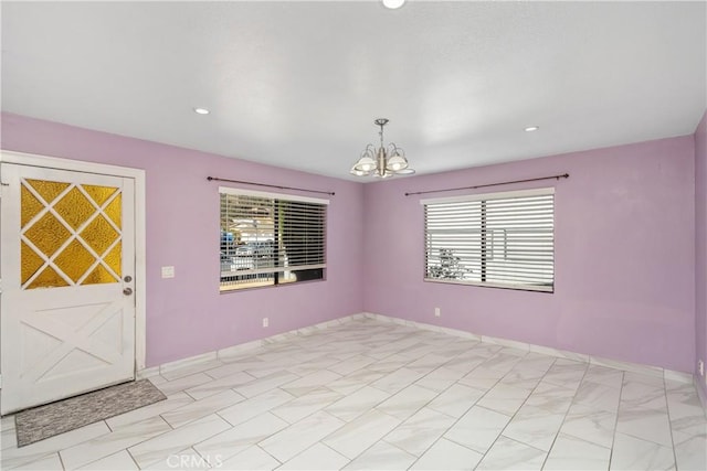 unfurnished room with a chandelier