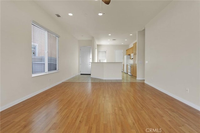 unfurnished living room featuring light hardwood / wood-style flooring and ceiling fan