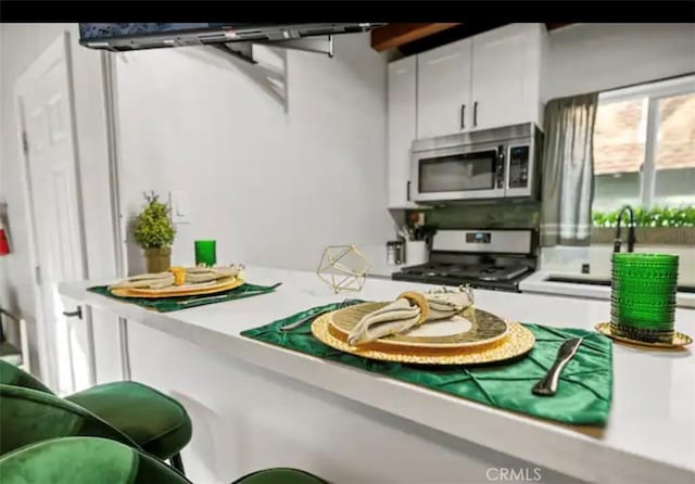 kitchen with white cabinetry, appliances with stainless steel finishes, and sink