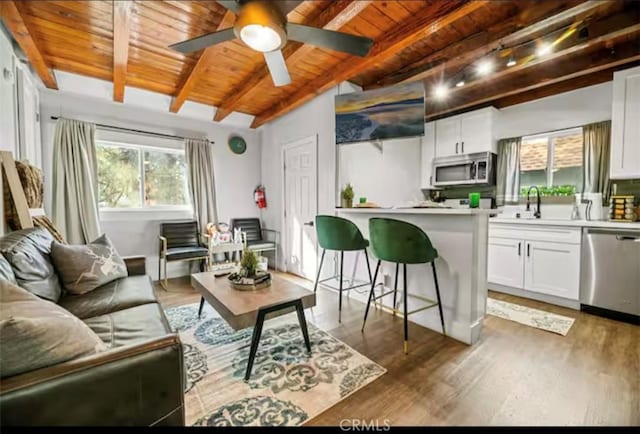 living room with wood ceiling, ceiling fan, dark hardwood / wood-style flooring, and beam ceiling