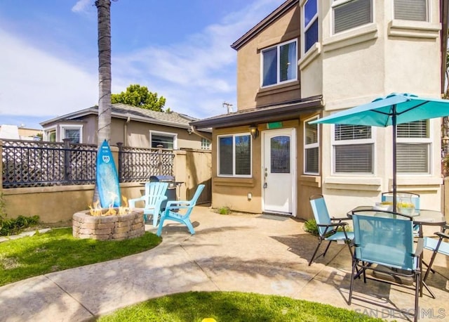 back of house featuring a fire pit and a patio