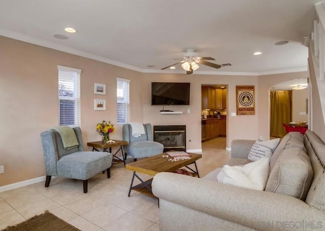 living room with light tile patterned floors, crown molding, and ceiling fan