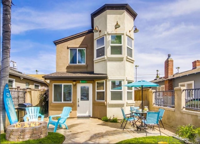 back of house with a fire pit and a patio area