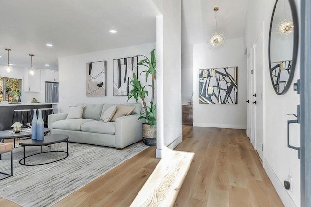 living room with a notable chandelier and light wood-type flooring